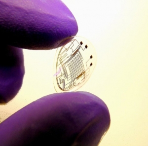 Сотрудник лаборатории в Университете Вашингтона держит в руках первый прототип контактной линзы с интегрированной схемой. (кликните картинку для увеличения)